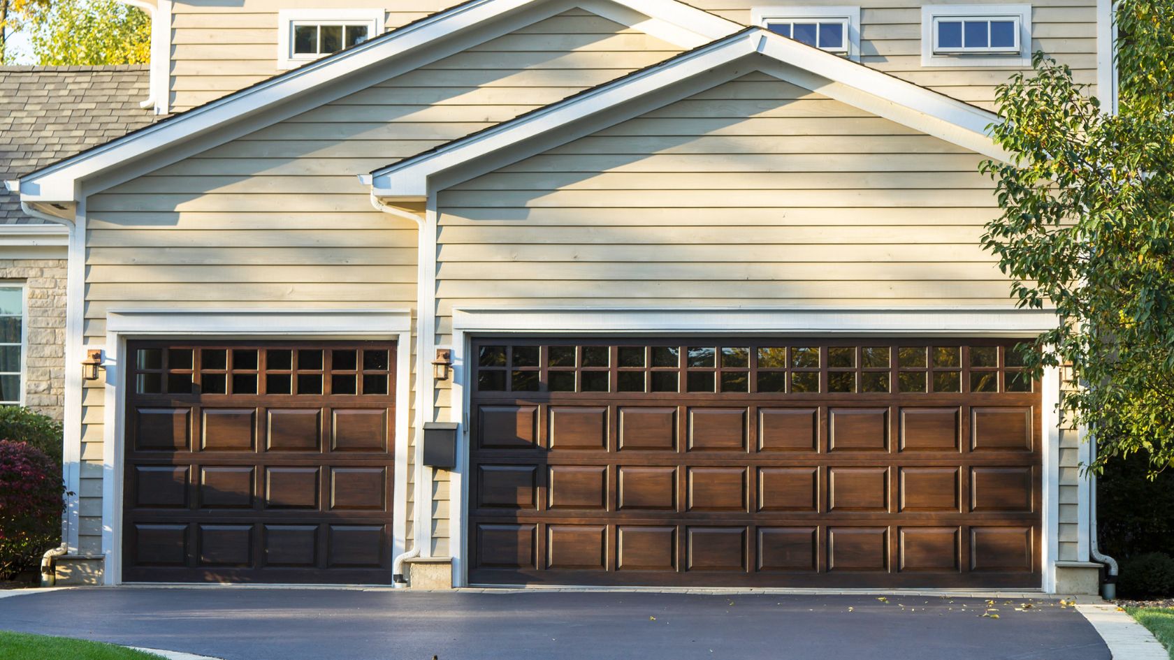 A brown garage door is open in front of a house