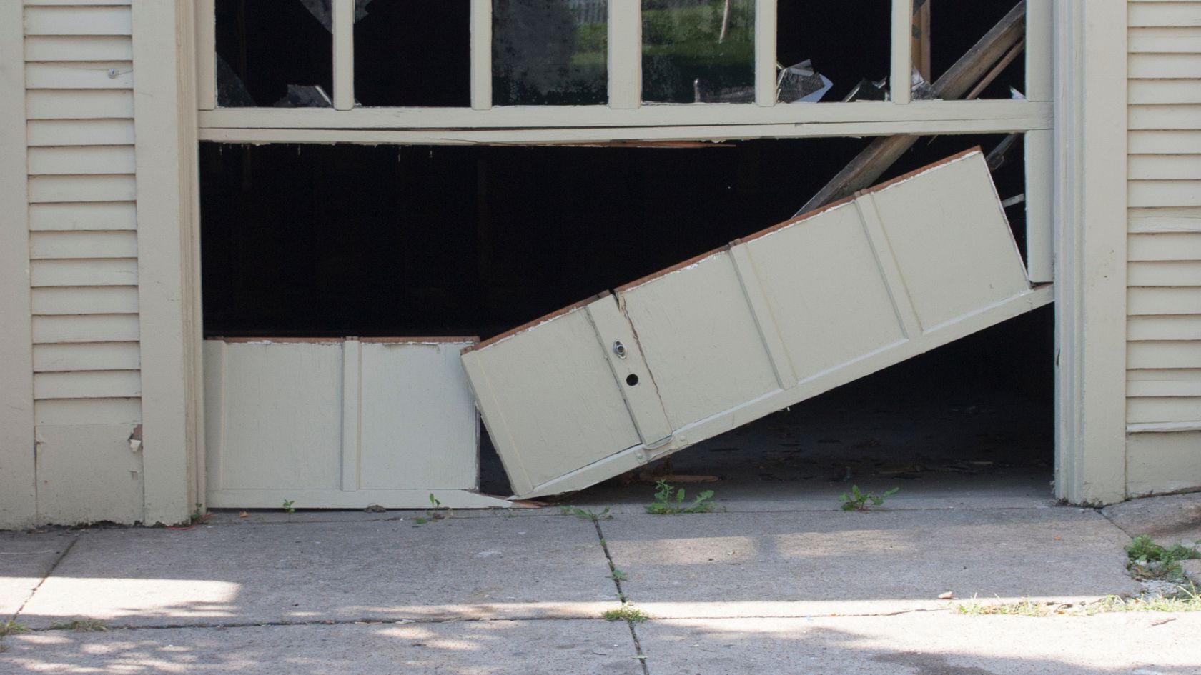 A white garage door with a broken window
