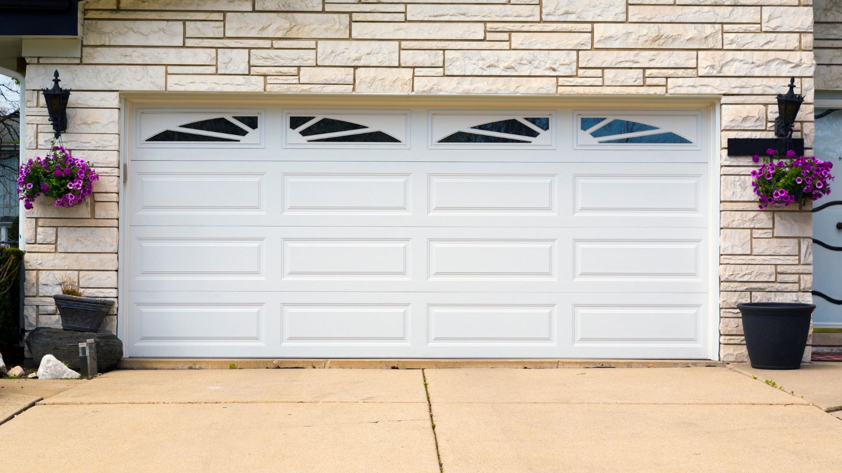 A white garage door with flower pots in front of it