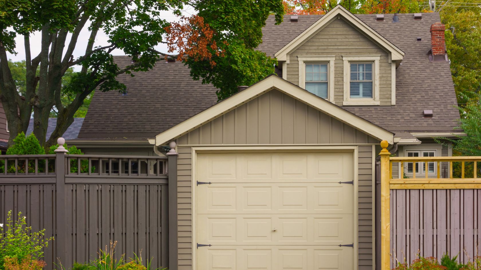 A house with a yellow gate and a brown fence